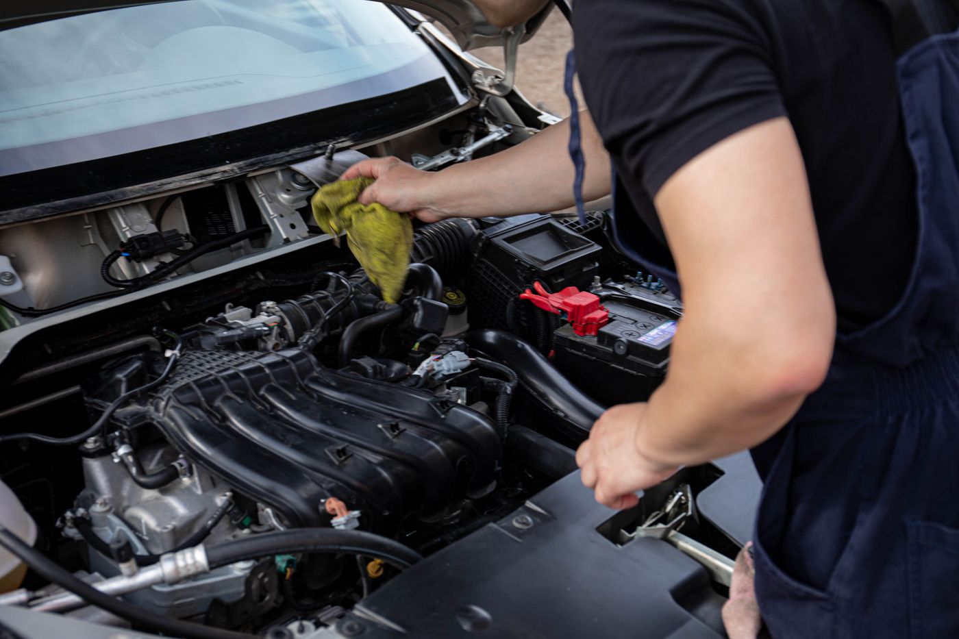 Mechanic holding a shop rag while working beside a vehicle